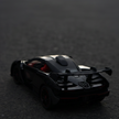 Black toy car on a dark surface