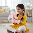 Child playing with Claptales pink teddy soft toy for comforting and cuddling
