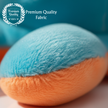 Close-up of a ball of blue and orange yarn with 'Premium Quality Fabric' label.