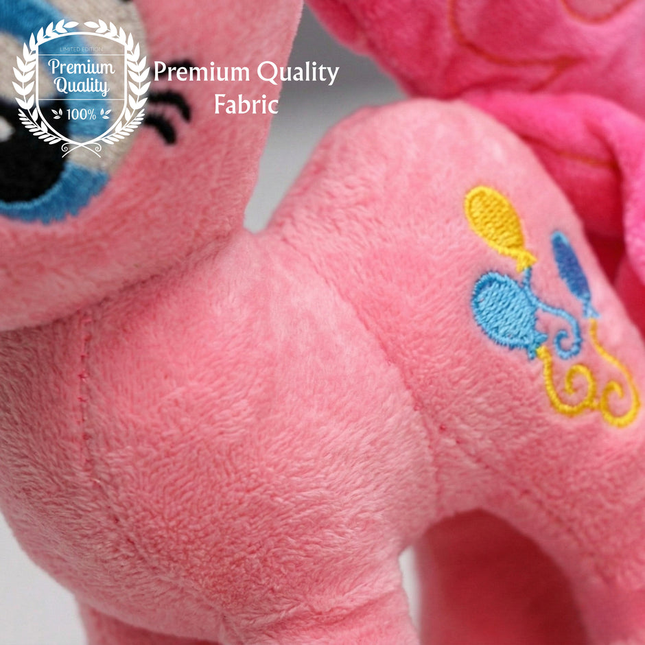 Close-up of a pink plush toy with embroidered details, featuring a 'Premium Quality Fabric' label.