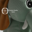 Close-up of a plush elephant toy with a 'Premium Quality Fabric' label.