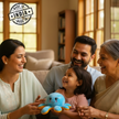 Family of four, including grandparents, sitting together in a living room with a blue plush toy.
