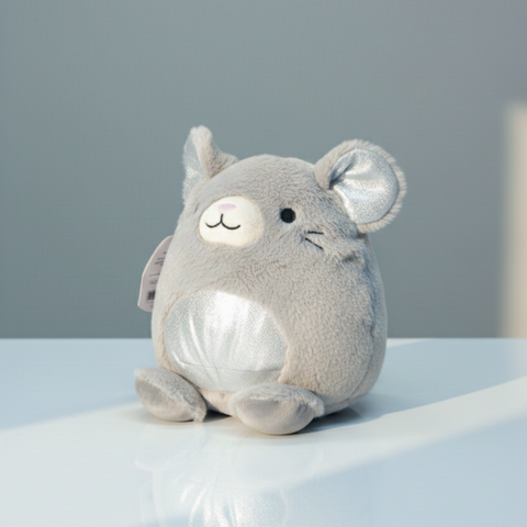 Gray plush toy with a smiling face on a light blue surface against a gray background