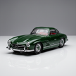 Green 1:32 die cast classic car models placed side by side on a reflective surface