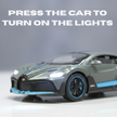 Model car with illuminated headlights on a gray background