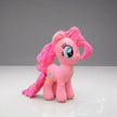 Pink plush toy with a bow on a gray background