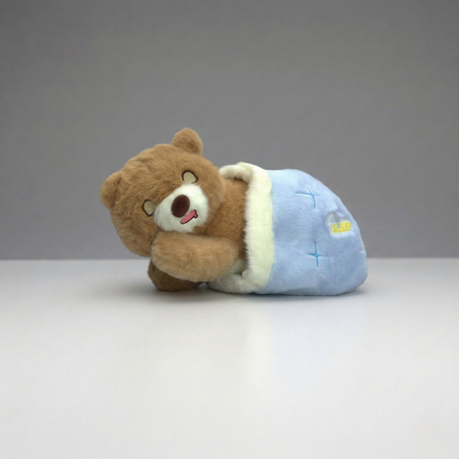 Plush bear toy in a blue outfit on a gray background
