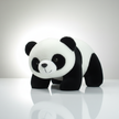 Plush panda toy on a reflective surface with a light gray background