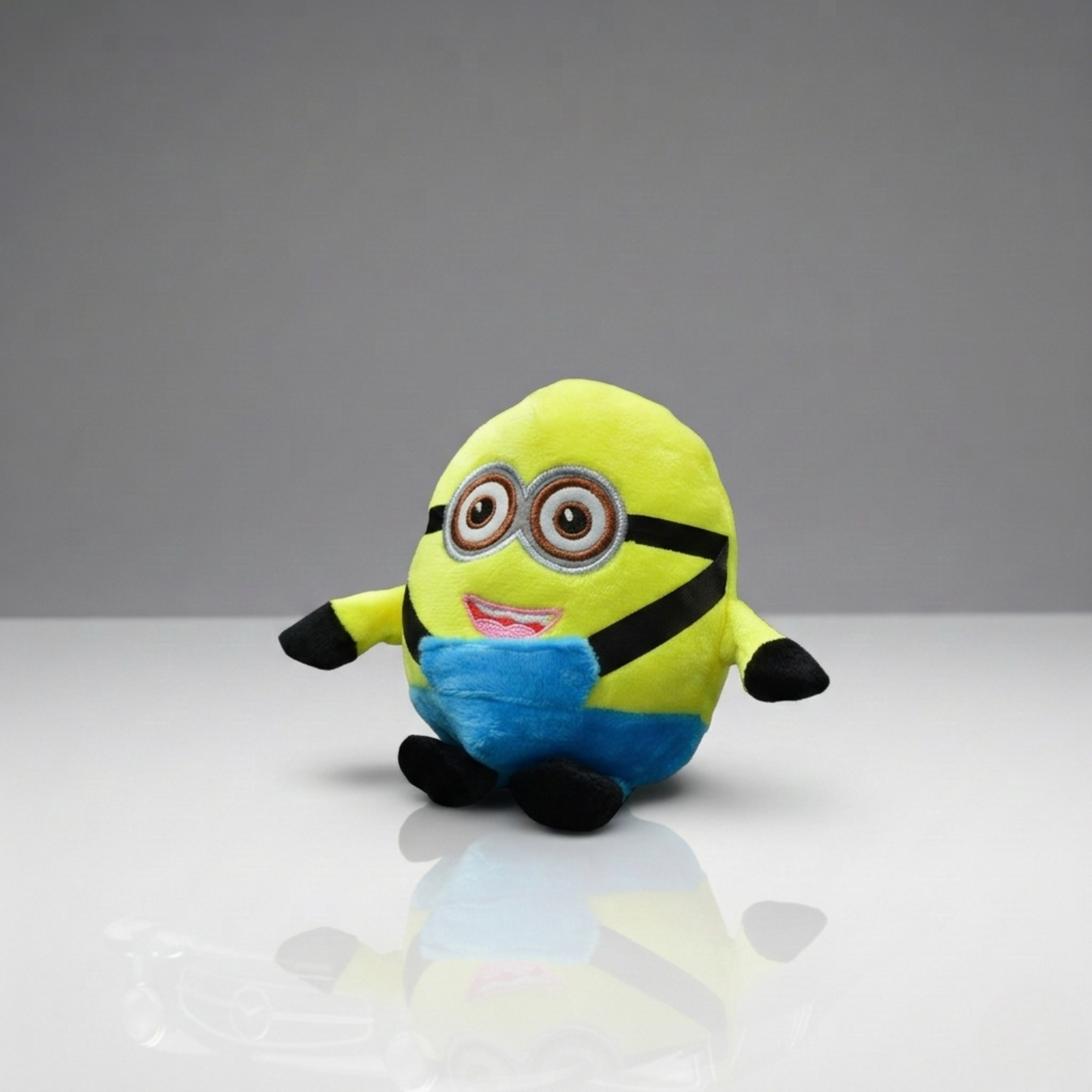 Plush toy resembling a character from a popular movie franchise on a reflective surface with a gray background