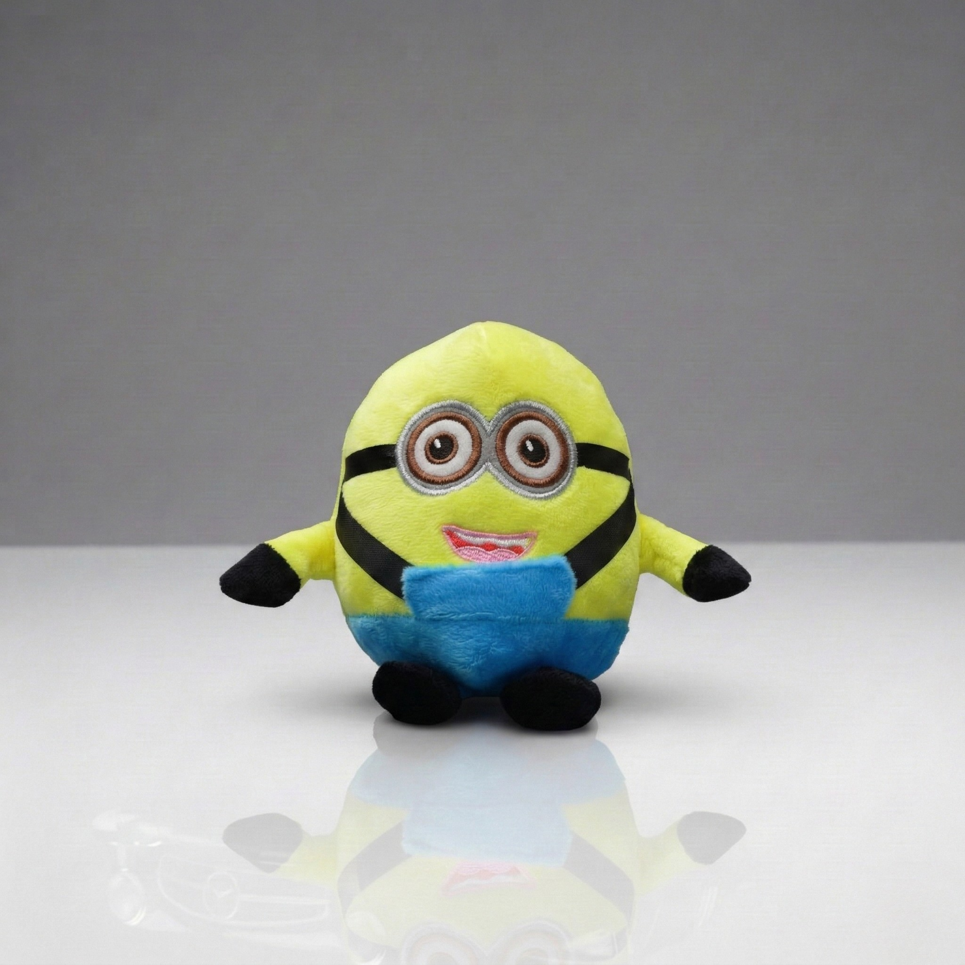 Plush toy resembling a character from a popular movie on a reflective surface with a gray background